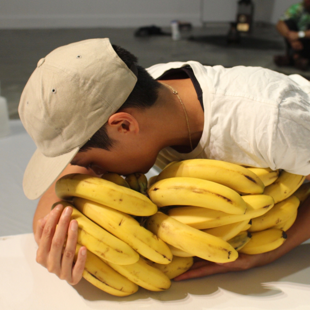 Sophia Mak with face in bunch of bananas